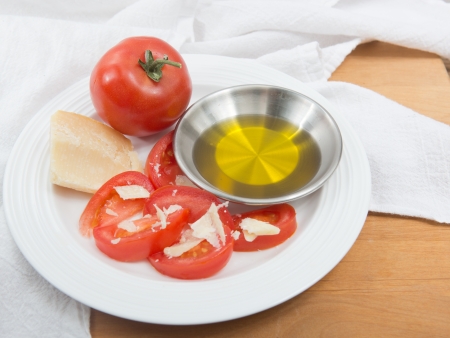 Plate of vine ripened red tomato with parmesan and olive oilの写真素材