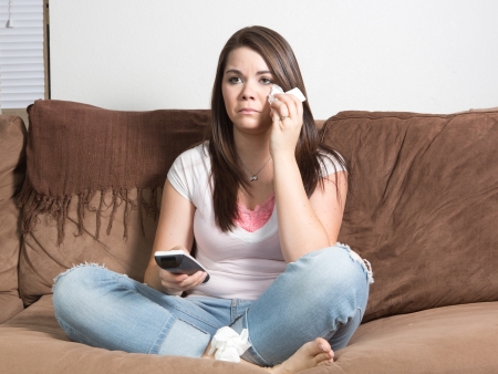 Tearful distraught woman pointing remote controlの写真素材