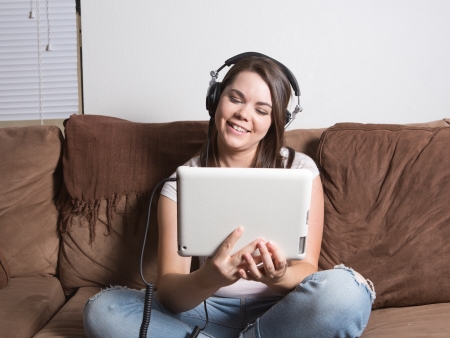 Smiling woman on tablet and headphonesの写真素材