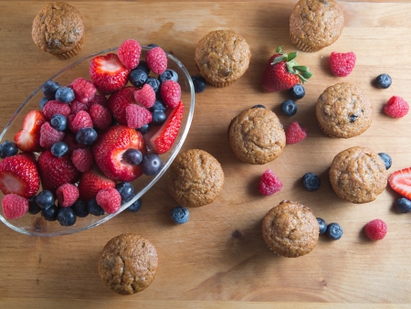 Berry and bran muffins with bowl of raspberry, strawberry and blueberryの写真素材