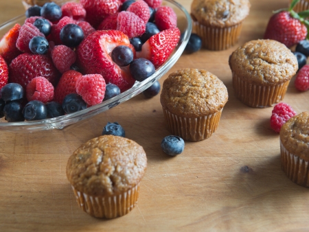 Berry and bran muffins with bowl of raspberry, strawberry and blueberryの写真素材