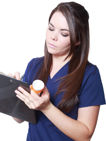 Female Medical Professional checking prescription against patient chartの写真素材