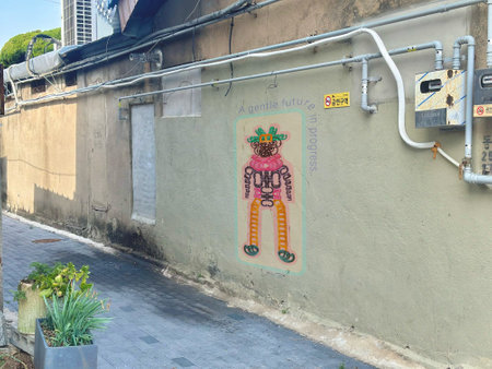 A conceptual street art composition featuring a colorful illustrated character placed on a quiet back alley wall in an urban Korean neighborhood.の写真素材