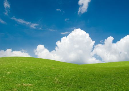 Rolling green hills under a blue summer sky.の写真素材
