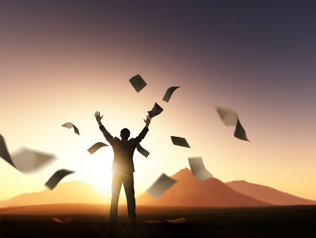 A businessman reaching for the sky and throwing paperwork.の写真素材