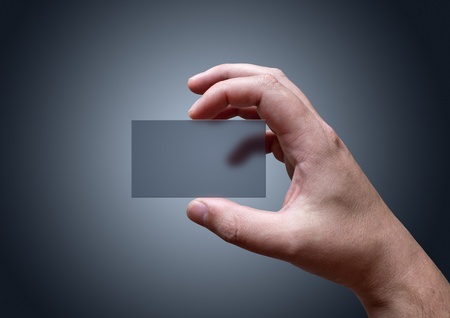 A hand holding a blank transparent business card.の写真素材