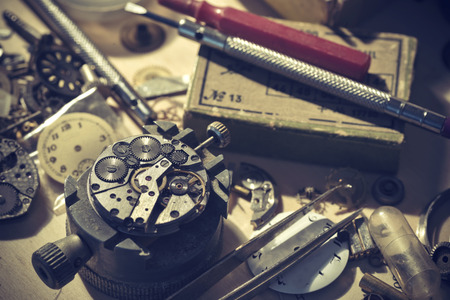 Old Watchmaker Studio. A watch makers work top. The inside workings of a vintage mechanical watch.の写真素材