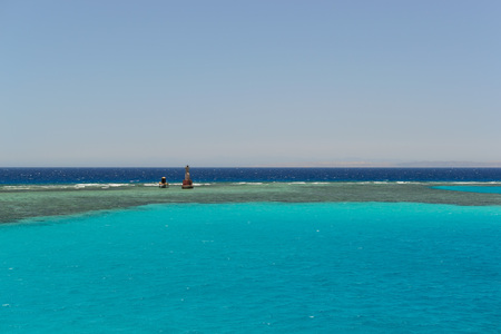 Lighthouse on the horizon of the blue sea photoの写真素材