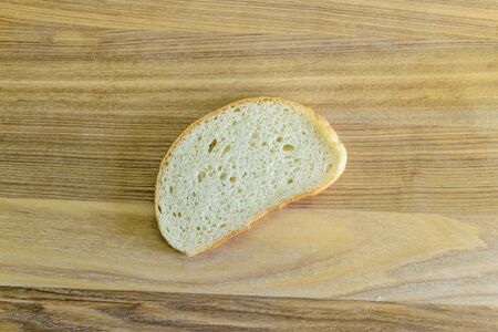 Hunch white bread on wooden board. Photo.