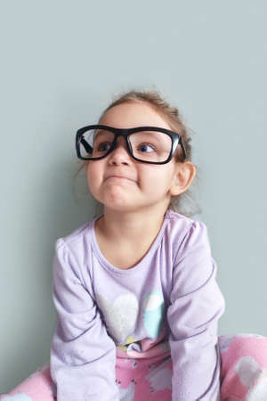 An important business girl with big glasses. Portrait of a smart child for education.の写真素材