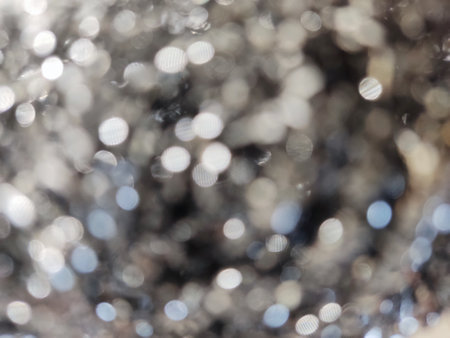 Abstract background of metallic blurred surface with bokeh spots. Art texture pattern design.