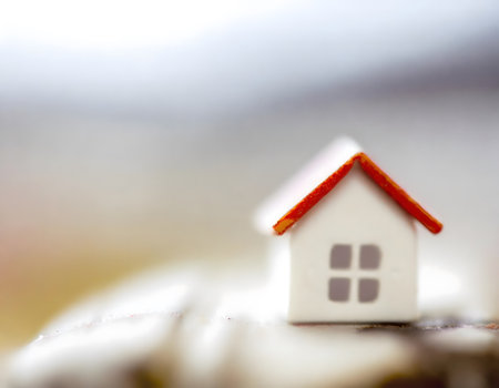 Miniature house is a symbol of mortgage and home ownership. Blurred background.の素材