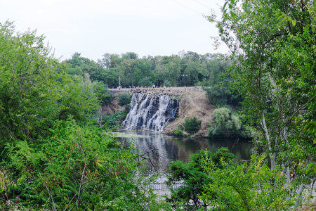 Beautiful waterfall scene in a lush green park, perfect for a relaxing getaway.の写真素材