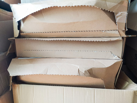 Stack of damaged cardboard boxes, showing wear and tear. Ideal for illustrating shipping, moving,...