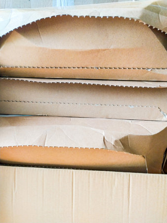 Closeup shot of stacked cardboard boxes, showing texture and slightly damaged edges. Perfect for...