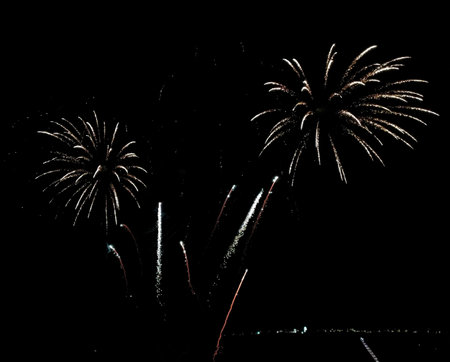 Stunning fireworks display against a dark night sky. Two large bursts illuminate the scene with...