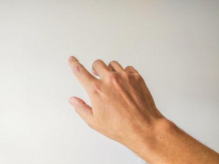 Closeup of a mans hand gesturing, finger pointing towards copy space. Clean, simple, and perfect for website banners, presentations, or app interfaces. Minimalist style, neutral background.の写真素材