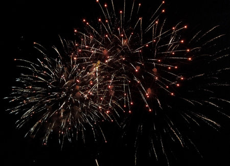 Spectacular fireworks display against a dark night sky. Two bursts of vibrant, shimmering lights...