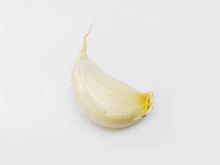 Single garlic clove, isolated on white. Clean, minimalist style. Perfect for food blogs, culinary websites, or healthy eating concepts. Versatile image conveying freshness and natural ingredients.の写真素材