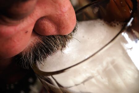 Closeup of the mustache face drinking beer