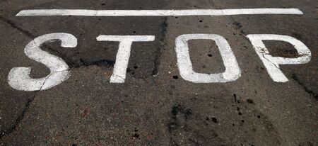 The white inscription of "STOP" on asphaltの写真素材