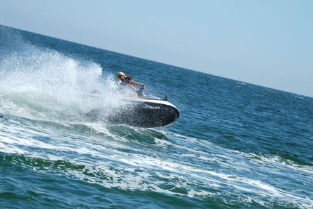 Man on a high speed jet ski with water spray
の写真素材