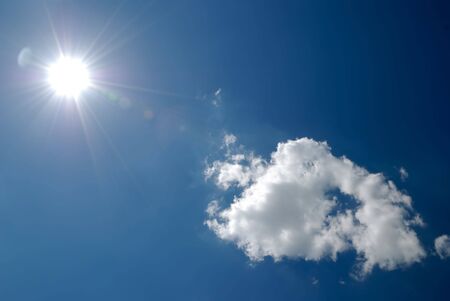 Soft white clouds against dark blue skyの写真素材