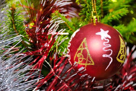 Red xmas ball hanging on pine twig with other decorationの写真素材