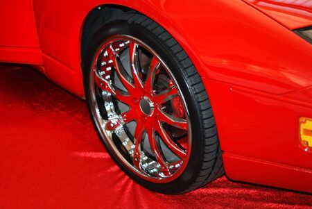 The chromeplated wheel on a red fabricの写真素材