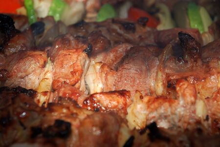 Meat slices with vegetables prepares on fireの写真素材