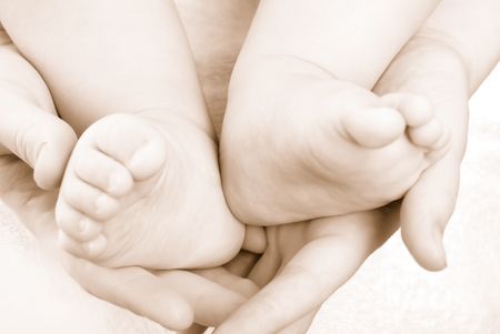 The caucasian baby feet in mommy's handsの写真素材
