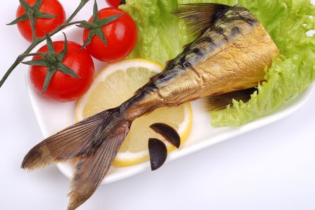 Composition from a smoked mackerel on a plate with vegetablesの写真素材