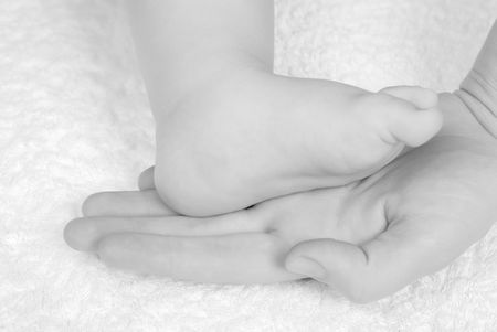 The caucasian baby feet in mommy's handsの写真素材