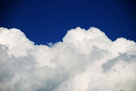 Hard white clouds against dark blue skyの写真素材