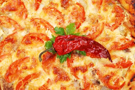 Background from a pizza with a tomato and chili pepperの写真素材