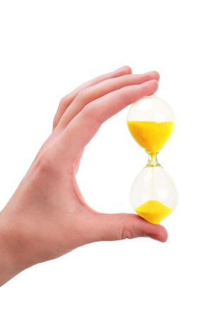 The female hand holds a sand-glass with sand of golden colour