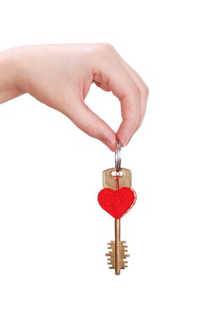 The woman hand holds a key to heart on whiteの写真素材