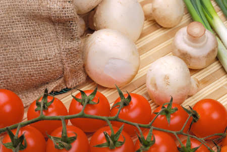 Composition from vegetables. Champignons, tomatoes and onion on a mat.の写真素材