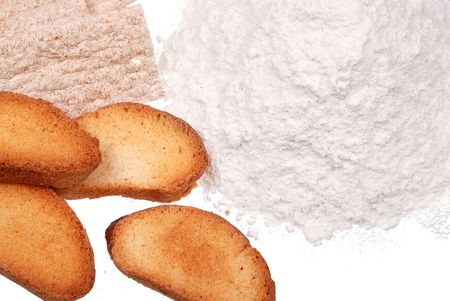 Bread, rusk and handful of wheat flour isolated on white