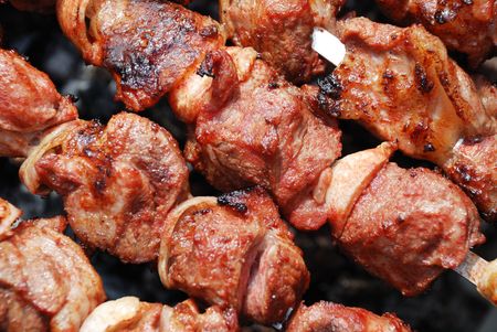 Juicy slices of meat with sauce prepare on fireの写真素材