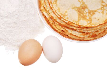 Pancake on a dish, a handful flour, and eggs isolatedの写真素材