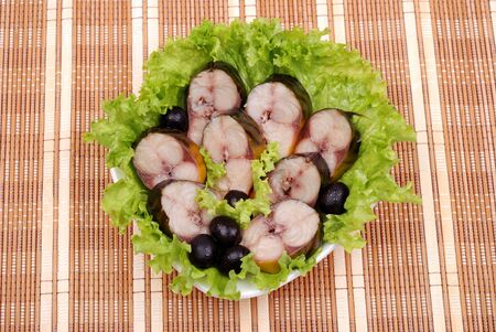Composition from a smoked mackerel on a plate with vegetablesの写真素材
