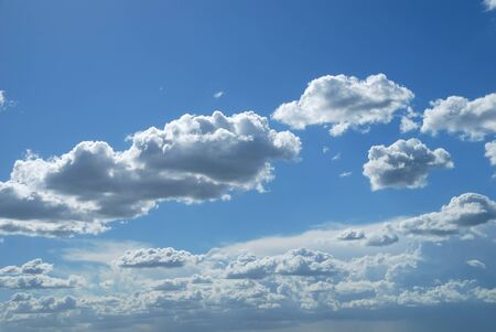 Bright sunny clouds against midday blue skyの写真素材