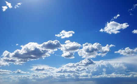 Bright sunny clouds against midday blue sky