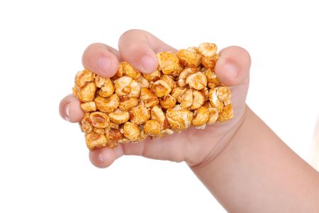 Children hand with sweet popcorn in honeyの写真素材