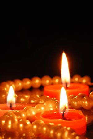 Burning candle and pearls on darkの写真素材