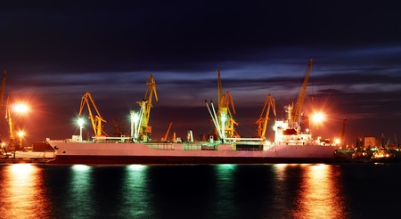 Port warehouse with cargoes and containers at nightの写真素材