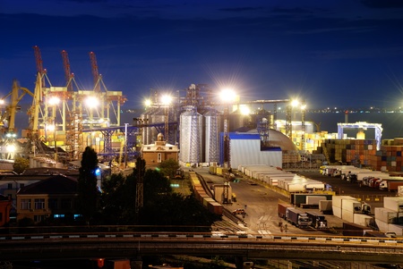 Port warehouse with cargoes and containers at nightの写真素材