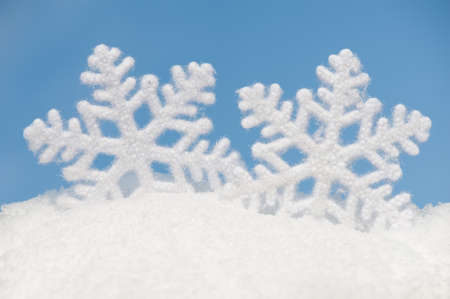two big snowflakes in snow on sky backgroundの写真素材