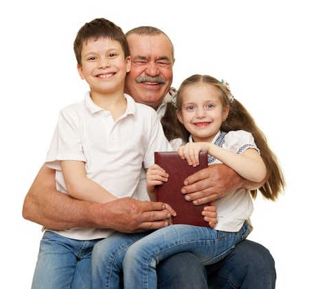 Grandfather and grandchildren read book on whiteの写真素材